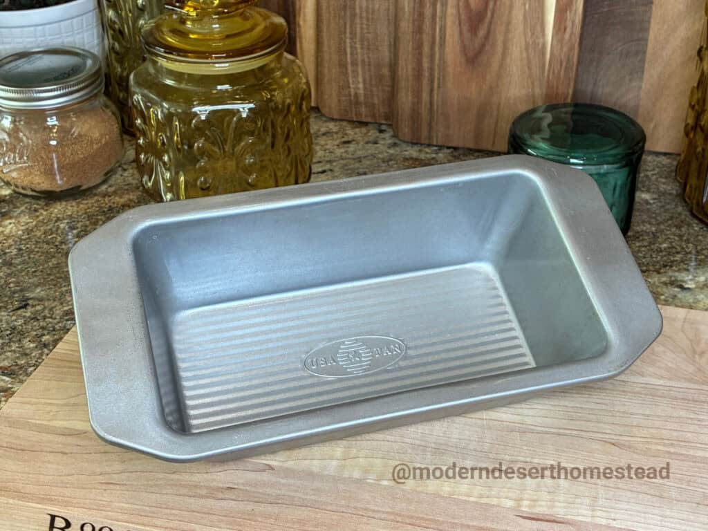 USA Pan 1 lb loaf pan on a wooden cutting board in a home kitchen