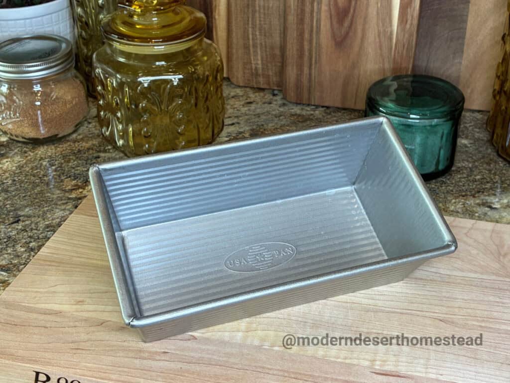 USA Pan 1 lb loaf pan on a wooden cutting board in a home kitchen