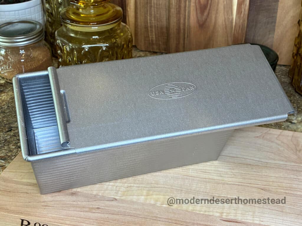 USA Pan 9 x 4 pullman pan on a wooden cutting board in a home kitchen
