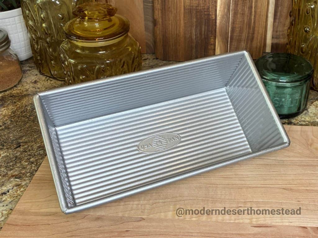 USA Pan 1.5 lb loaf pan on a wooden cutting board in a home kitchen